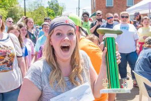 Woman holding a trophy as the winner of the pickle eating contest in Goldsboro North Carolina