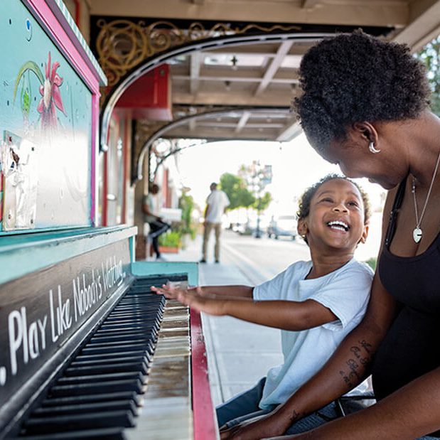 A mother and child playing piano in downtown Goldsboro North Carolina
